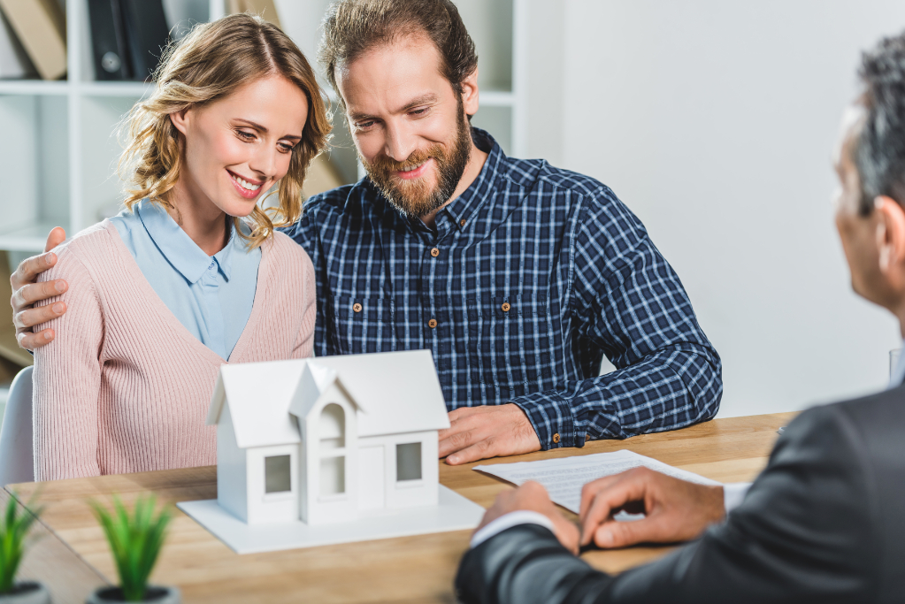 Couple looking at a white house model in a professional office setting