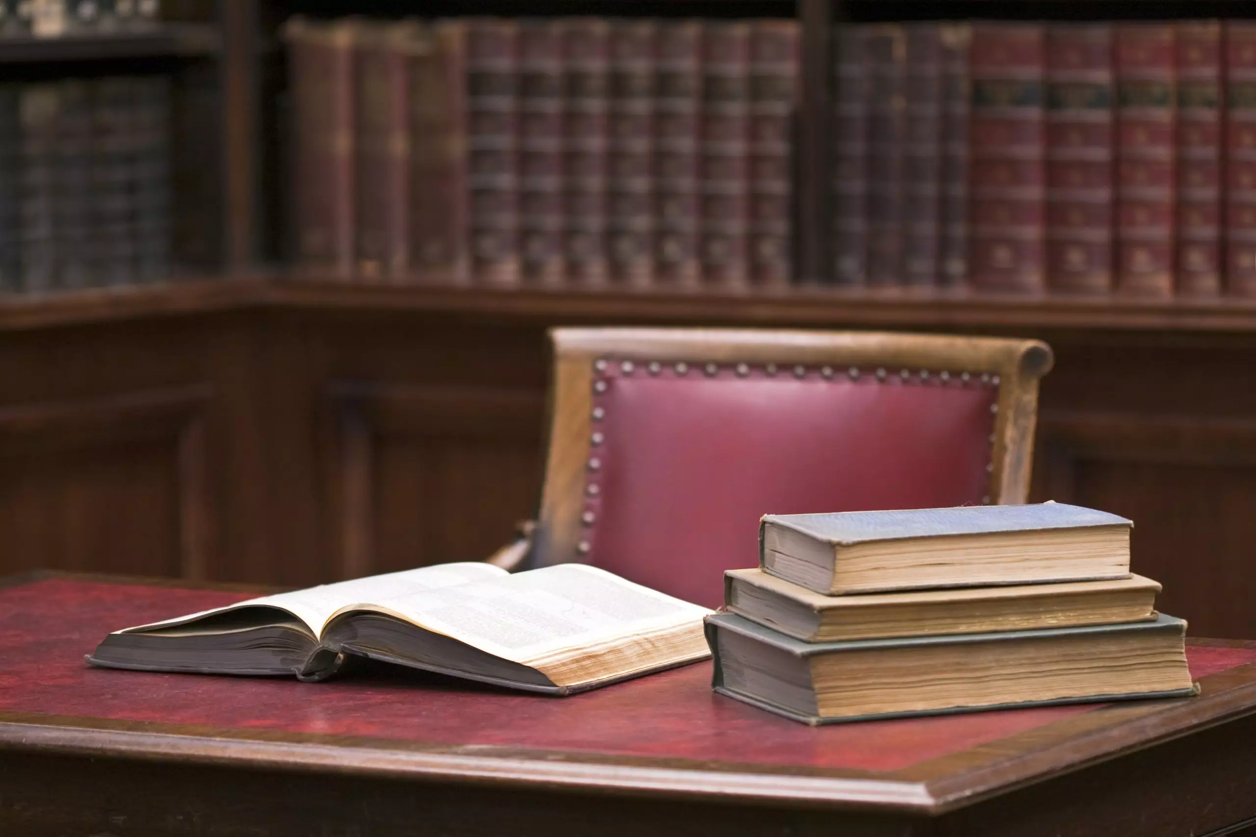 Red leather chair and open law books on table