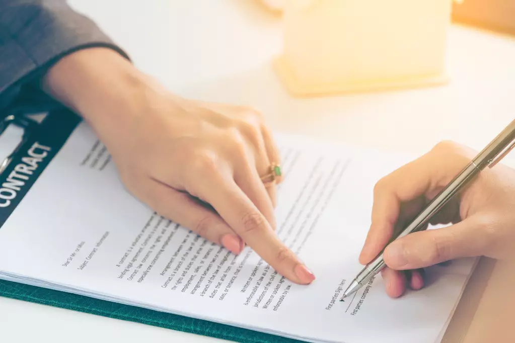 Female hands shown signing a contract